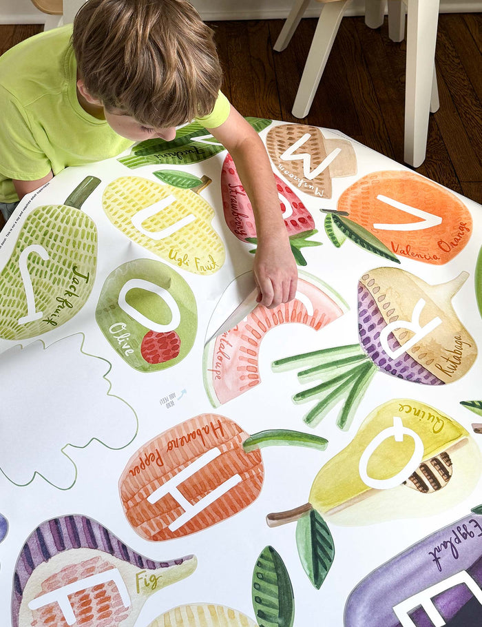 Child helping to install large watercolor wall decals in Nana's playroom.