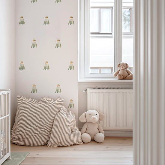 A sports-themed child’s nursery with watercolor badminton birdie wall decals by Mej Mej. A white crib and striped floor pillows complete the space.