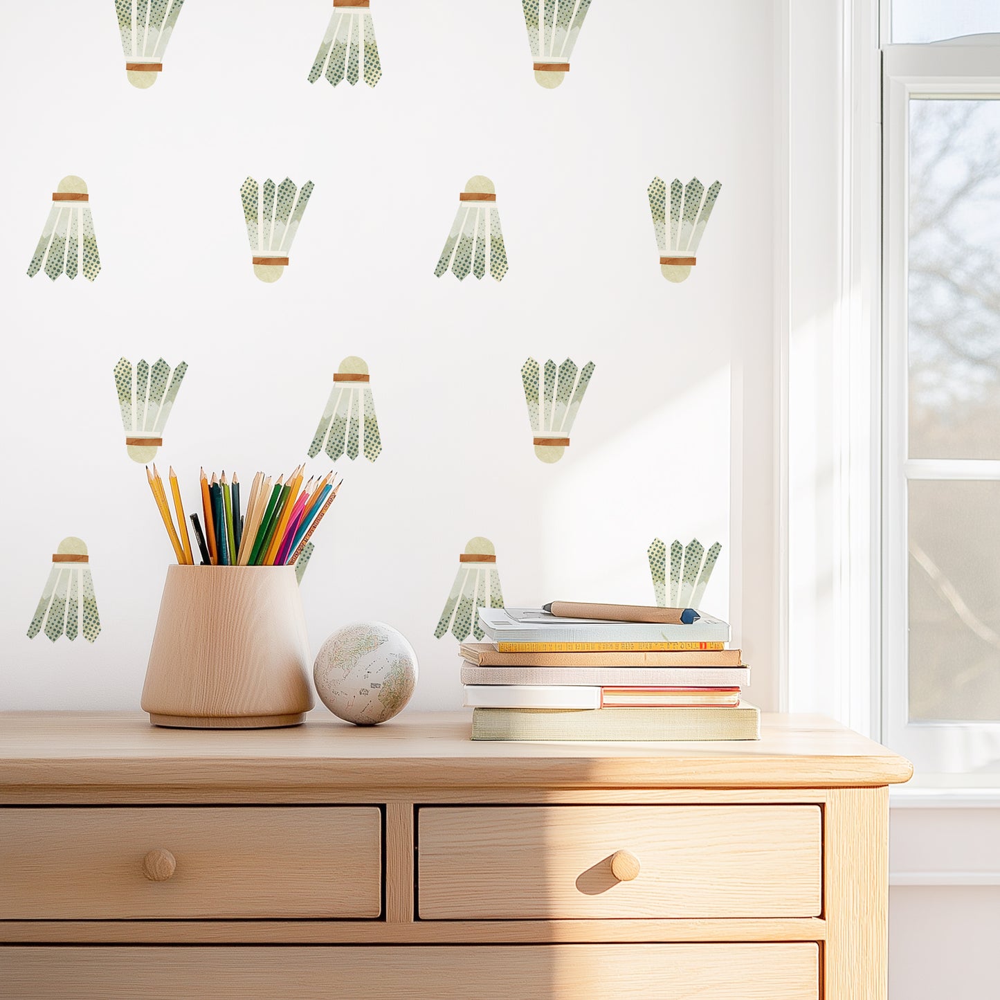 A wall is decorated with watercolor badminton birdie removable fabric wall decals by Mej Mej. They are placed in a grid pattern above a dresser for scale.