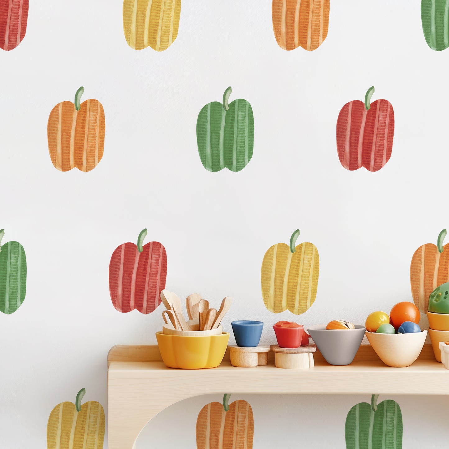 Modern kids’ kitchen setup with colorful bowls and red, yellow, green, and orange bell pepper decals on the wall