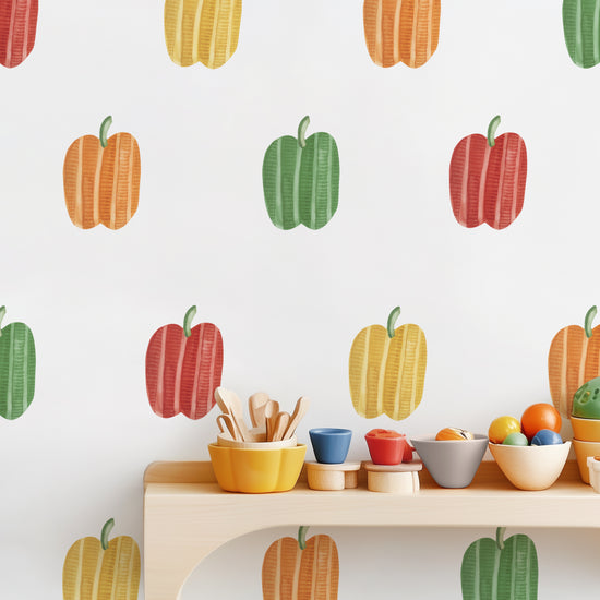 Modern kids’ kitchen setup with colorful bowls and red, yellow, green, and orange bell pepper decals on the wall
