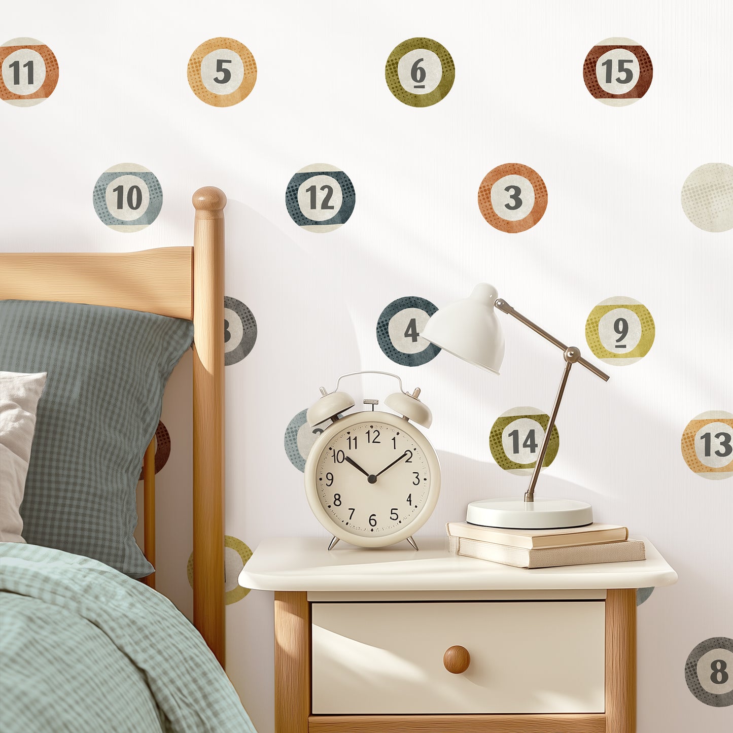 A white wall with billiard ball fabric decals placed in a grid pattern is the backdrop for a stylish bedroom. A bed with coordinating bedding, a nightstand with an oversized vintage alarm clock and gooseneck lamp completes the modern vibe.