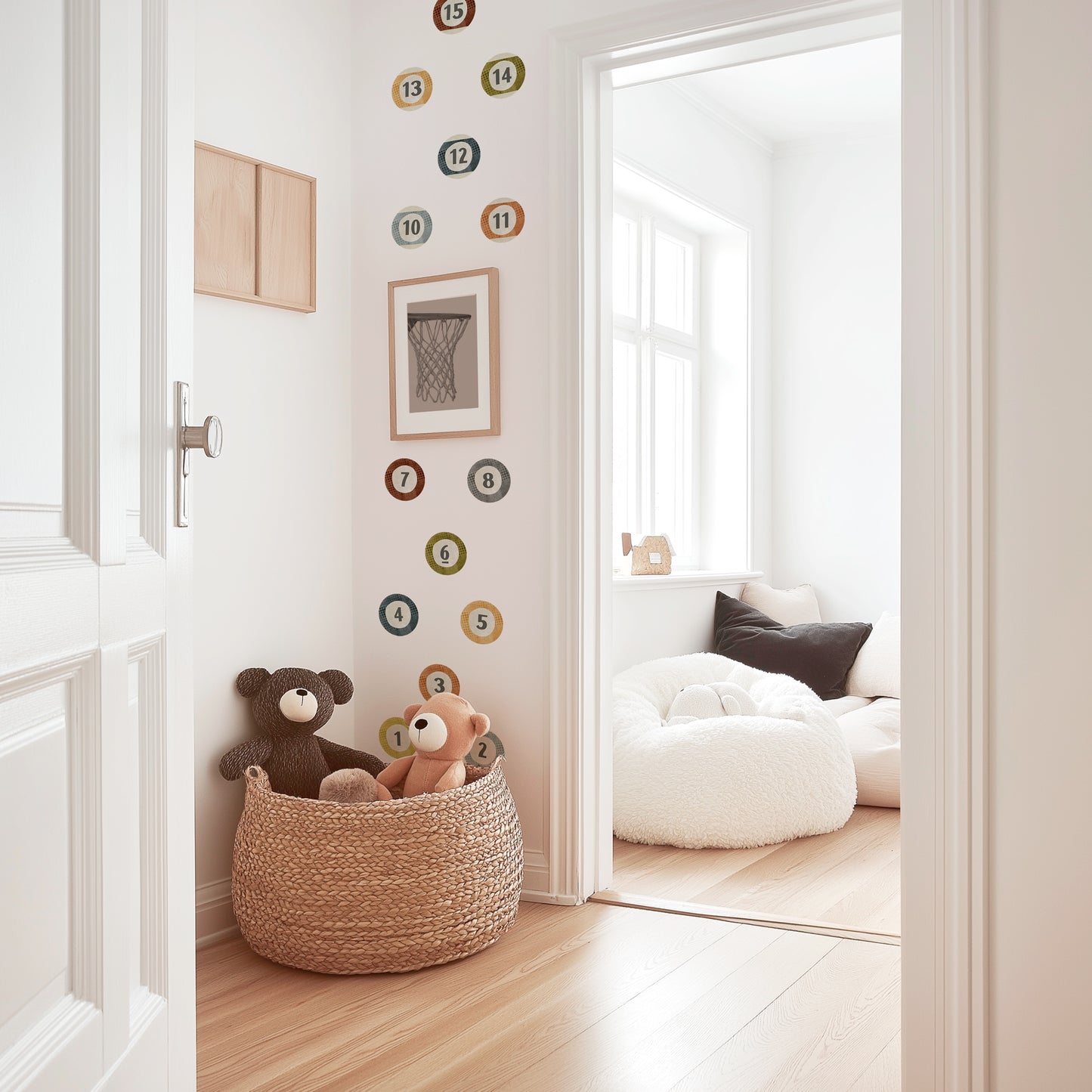 Watercolor billiard ball wall decals by Mej Mej adorn an accent wall in a playroom. The decals are placed in a grid pattern behind a framed black and white sports photograph.