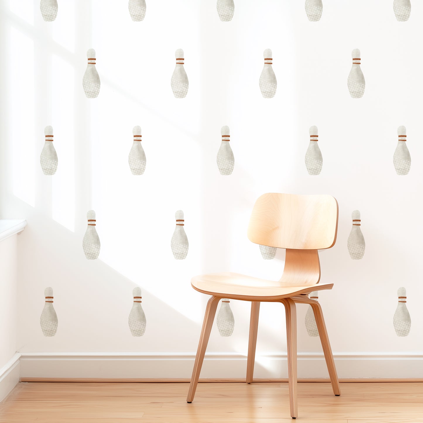 A wall is decorated with watercolor bowling decals by Mej Mej. They are placed in a grid pattern. A modern chair sits in front of them for scale.