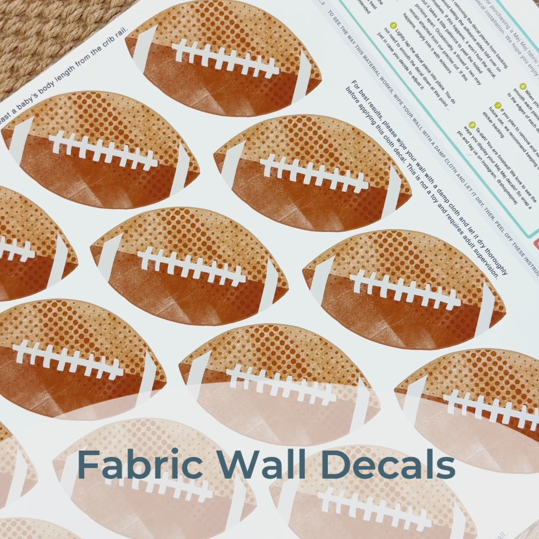Step-by-step guide of how to install Mej Mej’s peel-and-stick removable fabric wall decals featuring watercolor footballs. Perfect for sports-themed decor for football fans.