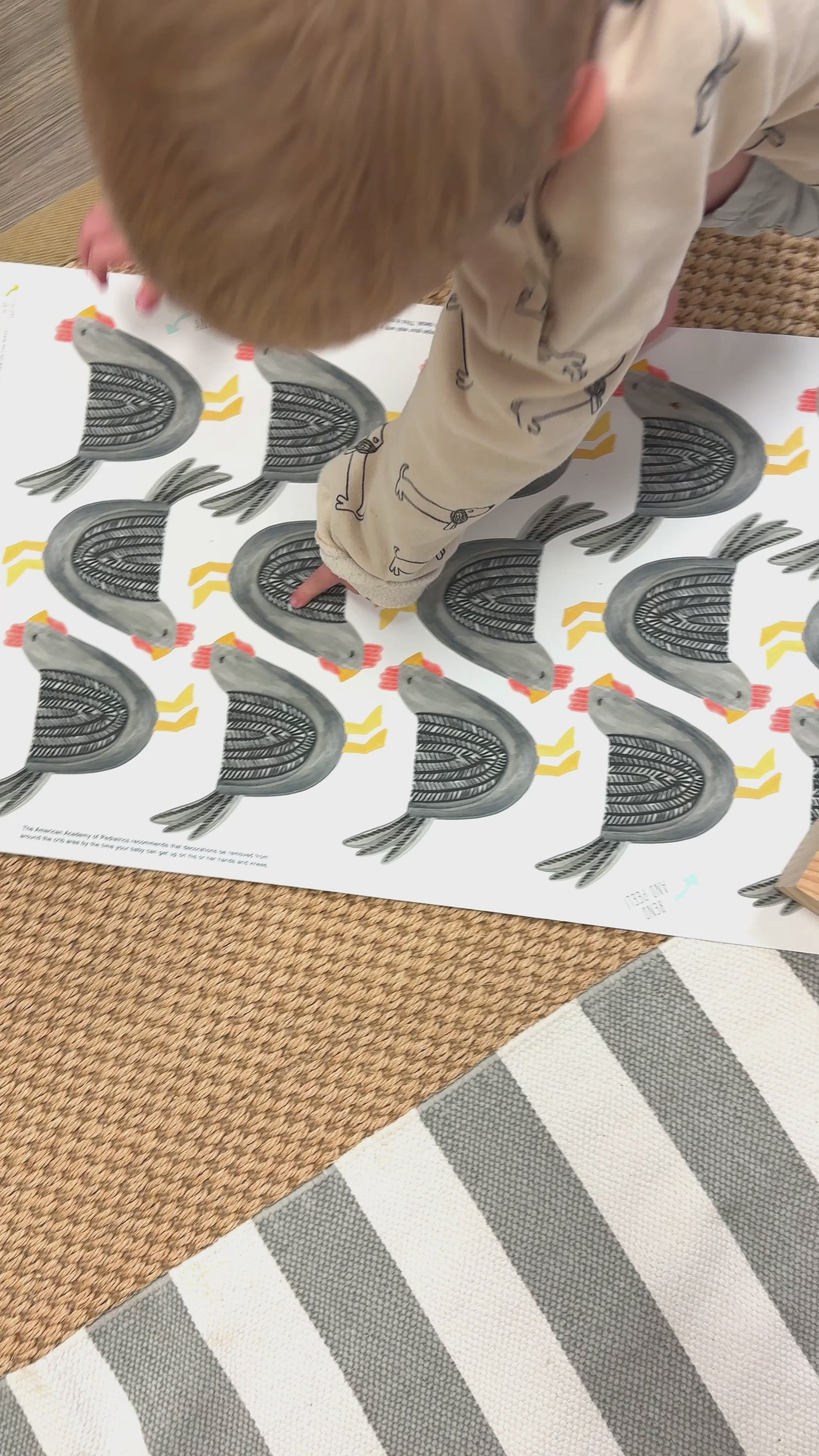video showing mom and toddler boy installing adorable gray chicken decals on the wall for a faux wallpaper style