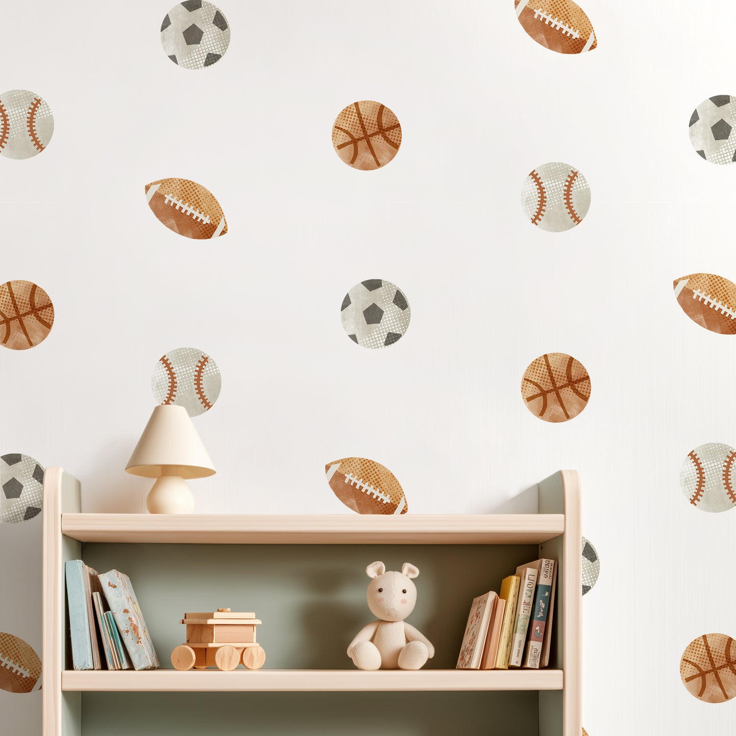 A wall is decorated with removable fabric wall decals of sports balls by Mej Mej. They are placed in a grid pattern on a wall above a bookshelf.