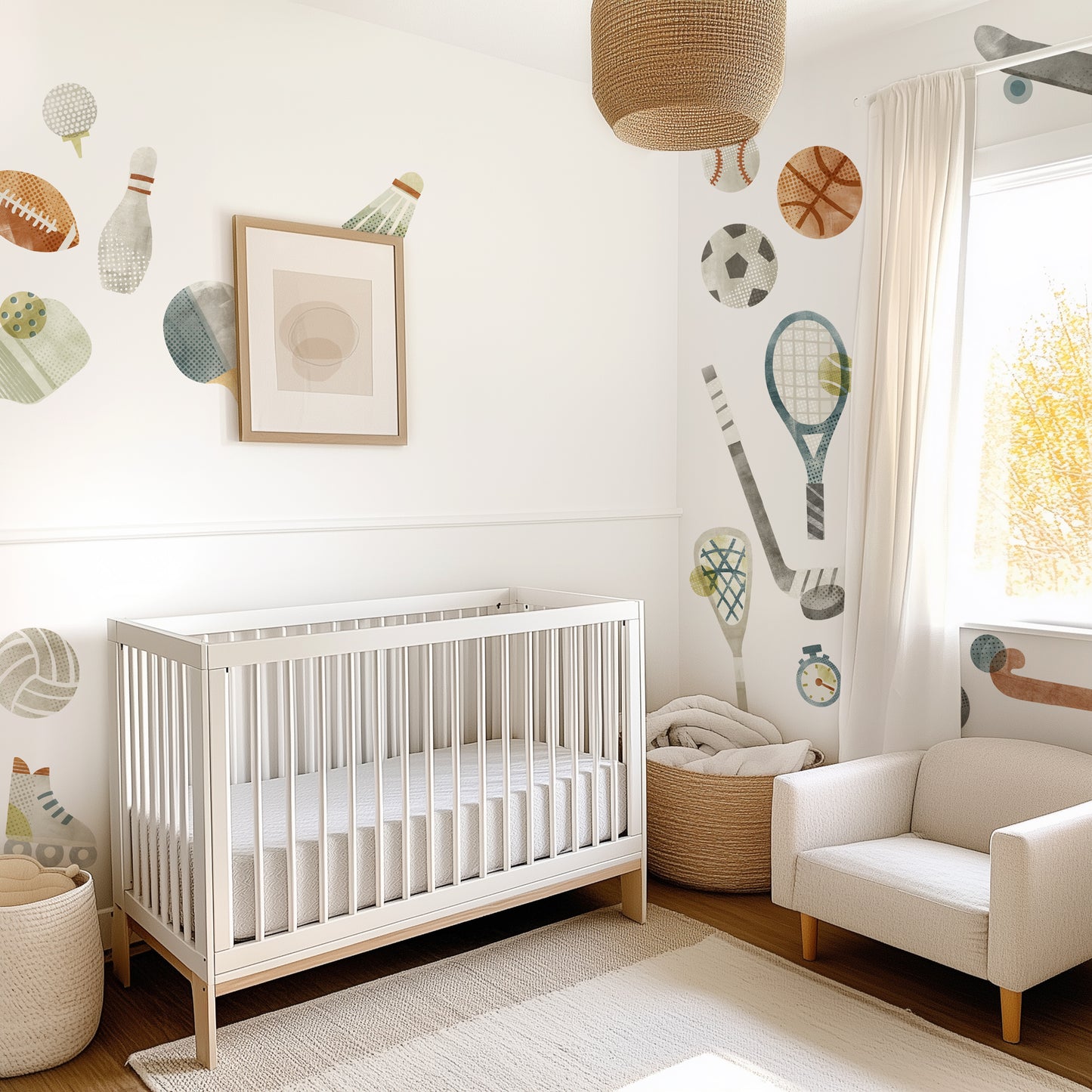 Mej Mej fabric wall decals of different pieces of sports equipment are the backdrop for a modern sports-themed baby nursery.