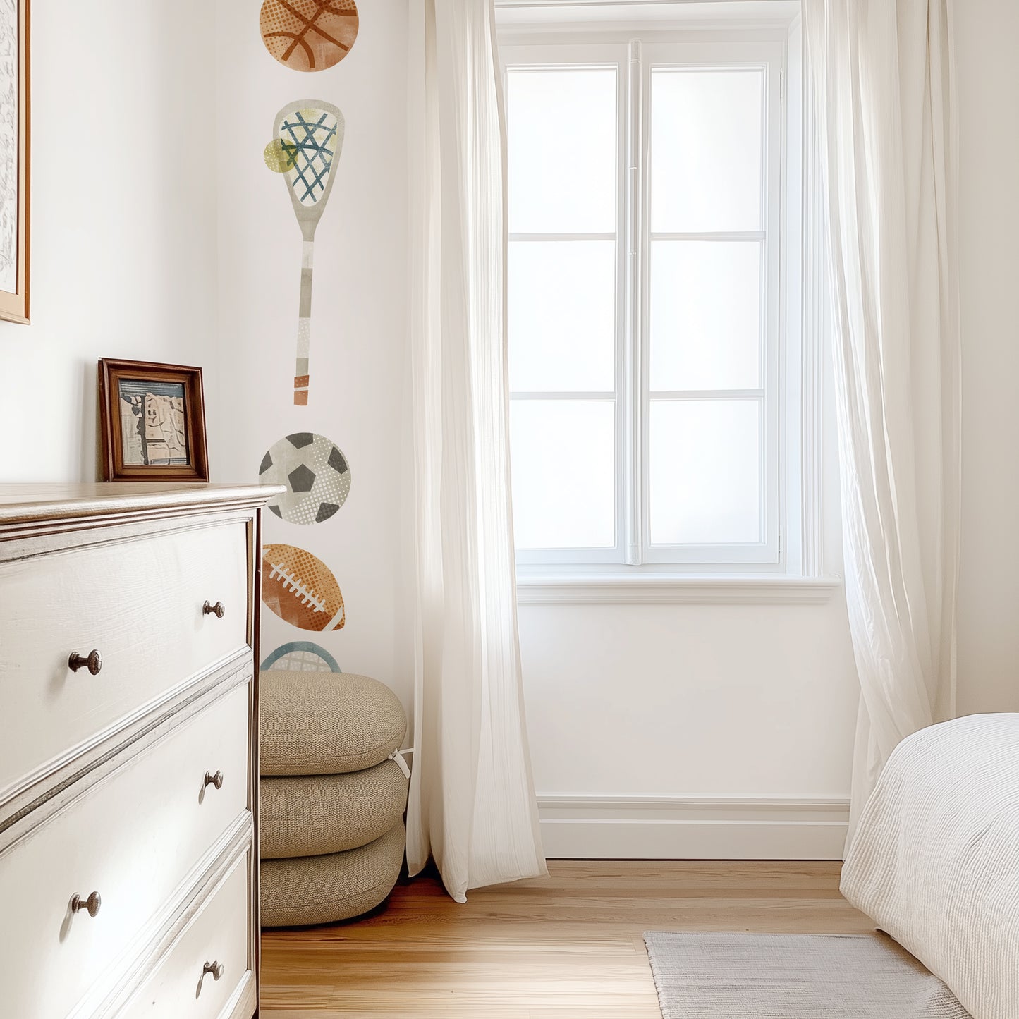 Removable fabric wall decals of sports equipment are arranged in a vertical stripe on an accent wall in a sun-filled teen’s room.