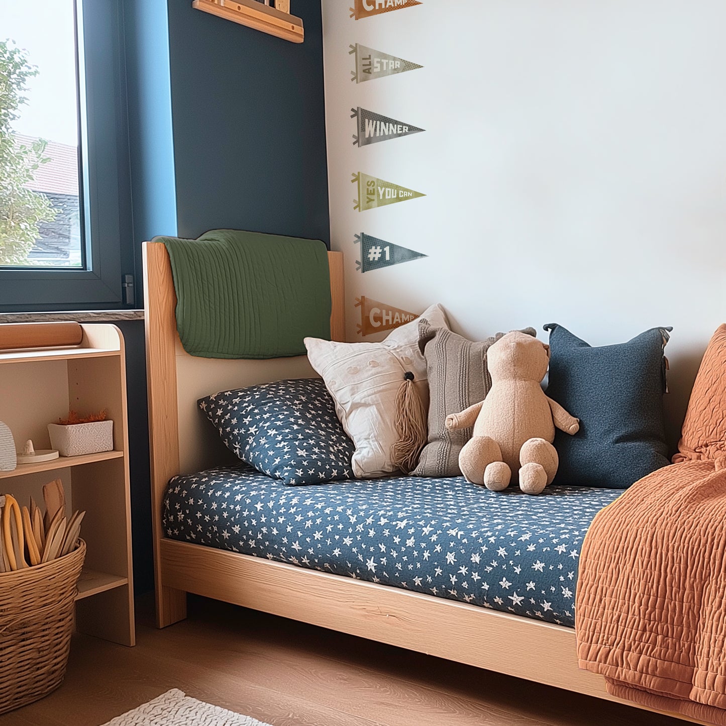 Watercolor Sports Pennants Wall Decals by Mej Mej are placed in a loose toss pattern on the wall behind a modern twin bed with navy sheets in a kids’ room.