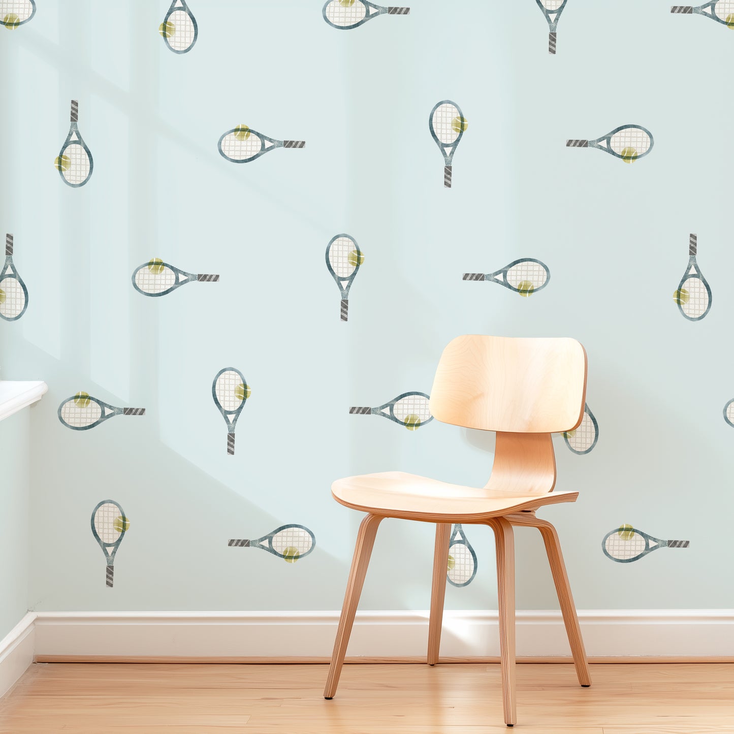 A pale blue wall is decorated with removable fabric wall decals of tennis rackets by Mej Mej. They are placed in a modern grid pattern. A mid-century chair sits in front of them for scale.