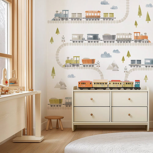 Neutral kids room with dresser and large peel-and-stick watercolor train decals arranged across a white wall