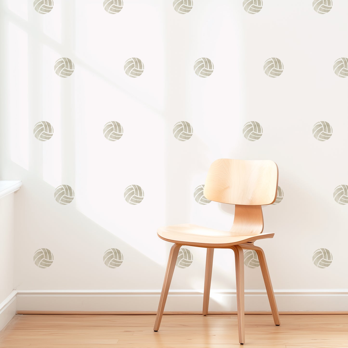 A wall is decorated with removable fabric wall decals of volleyballs by Mej Mej. They are placed in a modern grid pattern. A mid-century chair sits in front of them for scale.