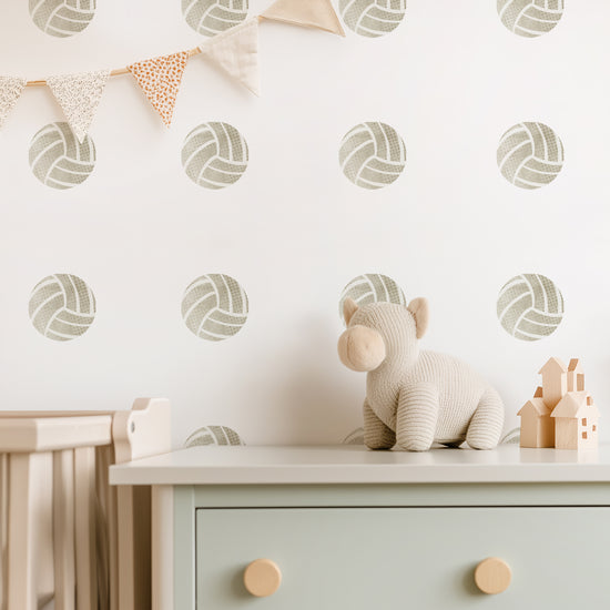 Watercolor volleyball fabric wall decals by Mej Mej are shown in a pattern on a wall behind a dresser in a child's space.